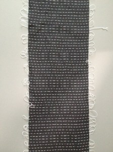 Handwoven Shibori scarf after weaving. See the pattern threads.
